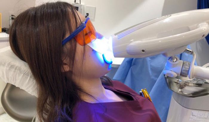 전문 치과에서 치아 미백 시술 중인 모습 / Professional in-clinic teeth whitening procedure using LED light device